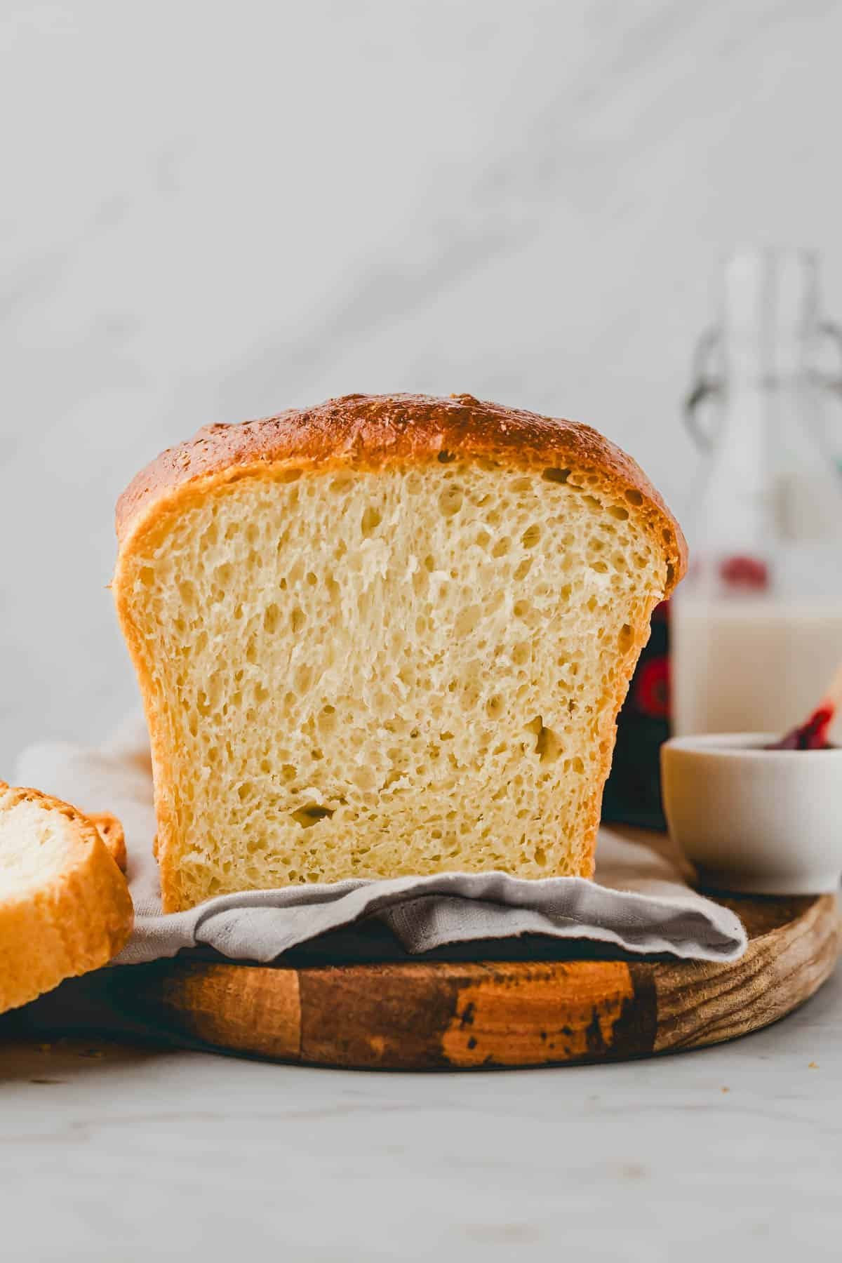 fertig gebackenes brioche brot angeschnitten auf einem holzbrett