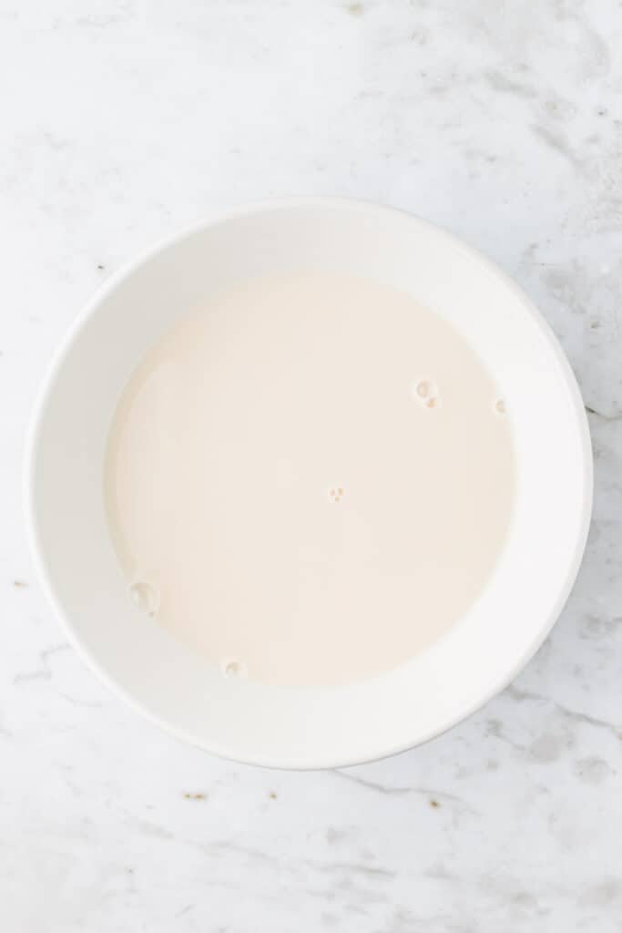 strained oat milk in a white bowl
