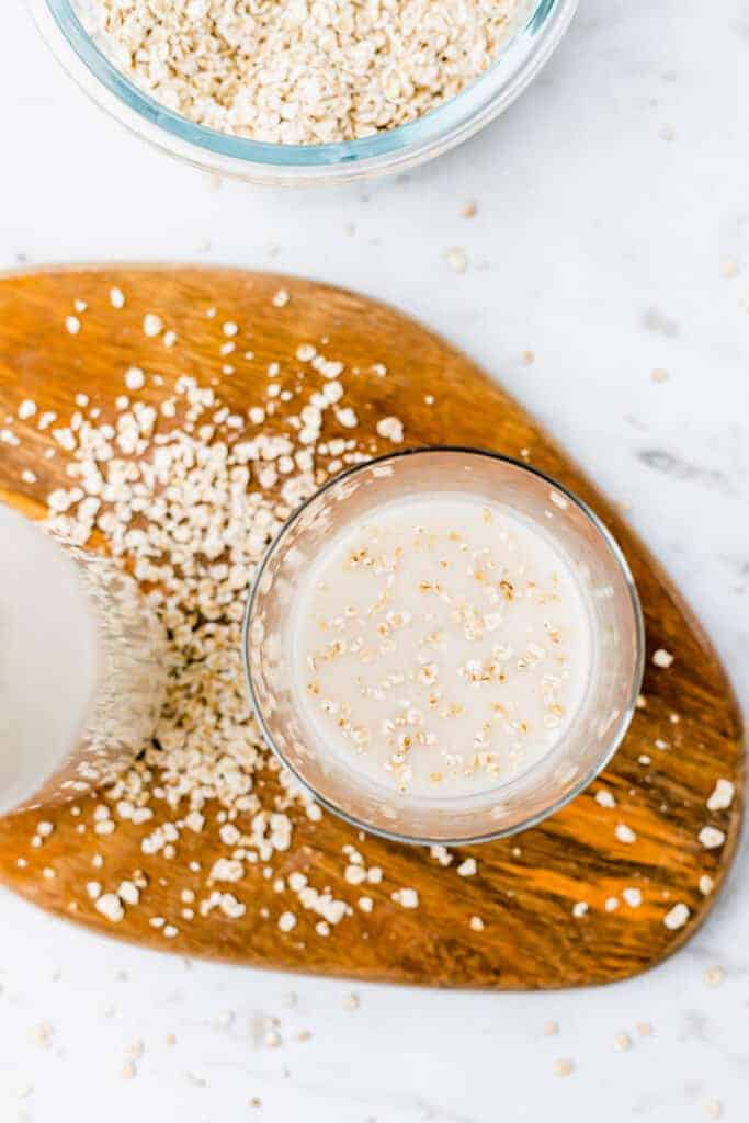 oat milk served in a glass with some oats on top