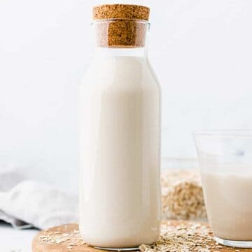 best oat milk served in a glass bottle on a wooden plate