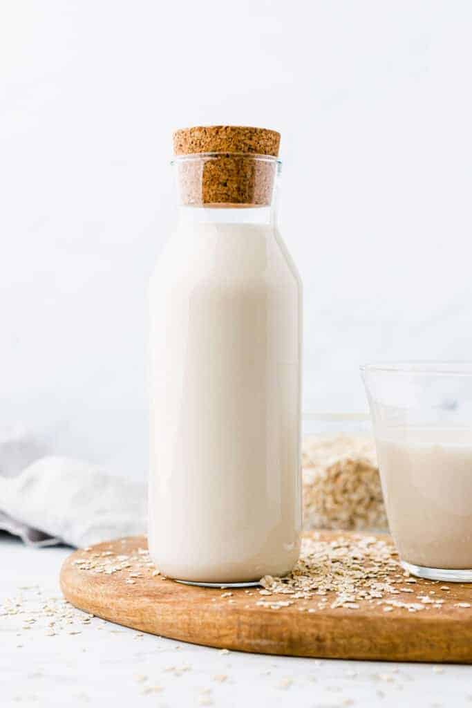 best oat milk served in a glass bottle on a wooden plate