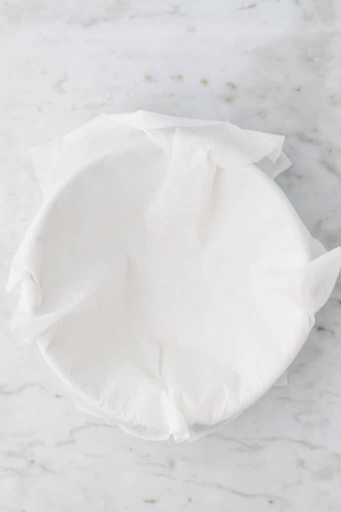 a cheesecloth over a white bowl