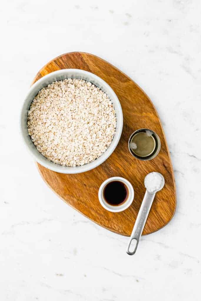 ingredients for oat milk recipe on a wooden plate