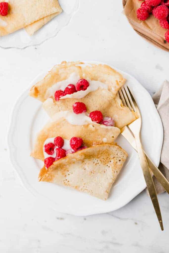 vegan crepes served with raspberries and soy yogurt