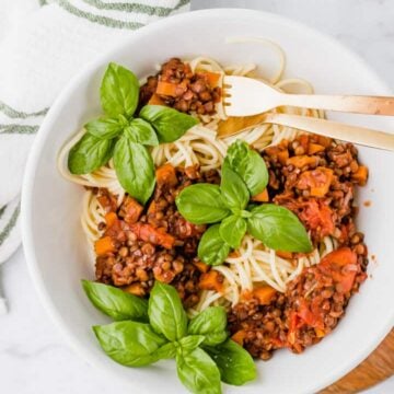 lentil bolognese served with a bowl of spaghetti