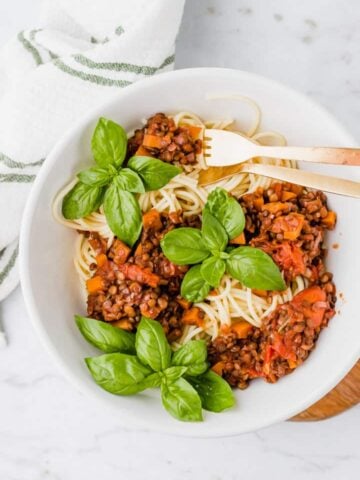 lentil bolognese served with a bowl of spaghetti