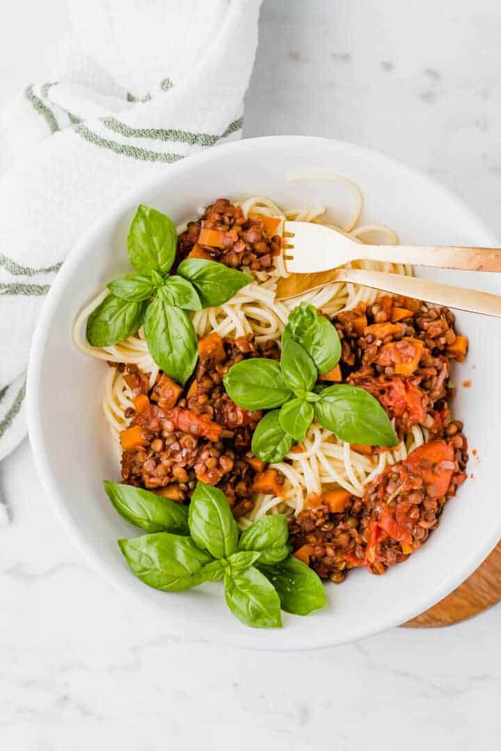 vegane spaghetti linsen bolognese mit frischem basilikum serviert