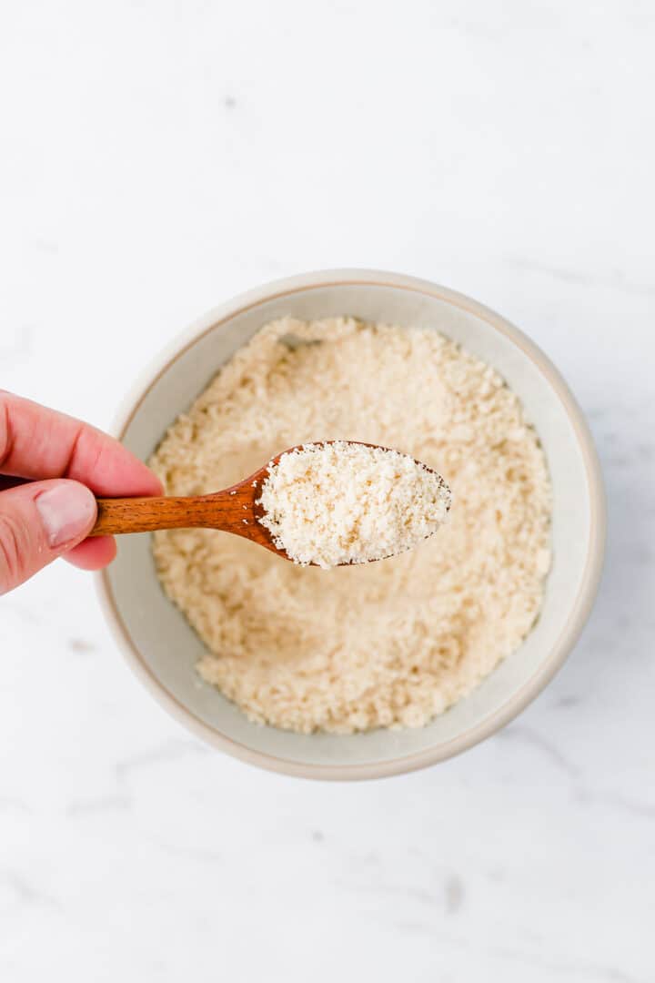 best vegan parmesan cheese on a wooden spoon