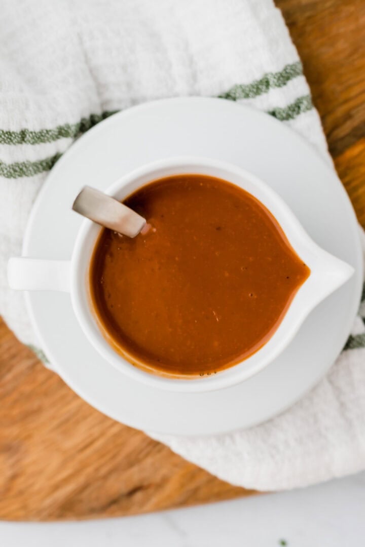 hausgemachte vegane bratensauce serviert in einem sauciere auf einem holbrett