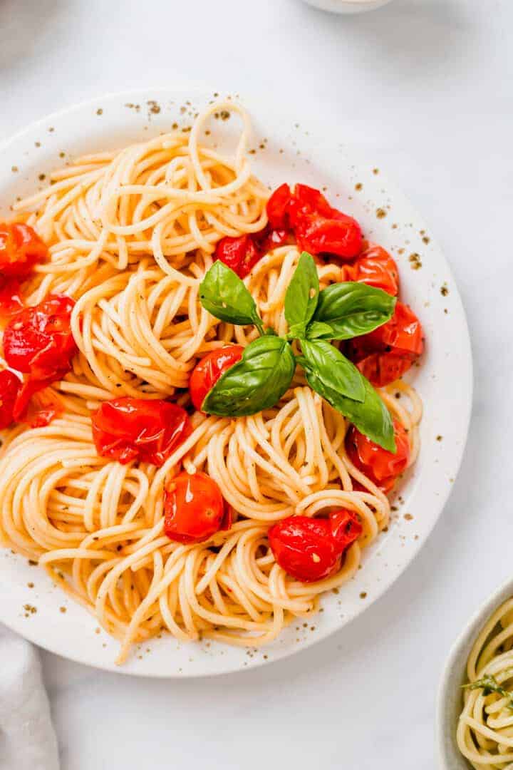 Spaghetti mit Ofentomaten auf einem weissen teller