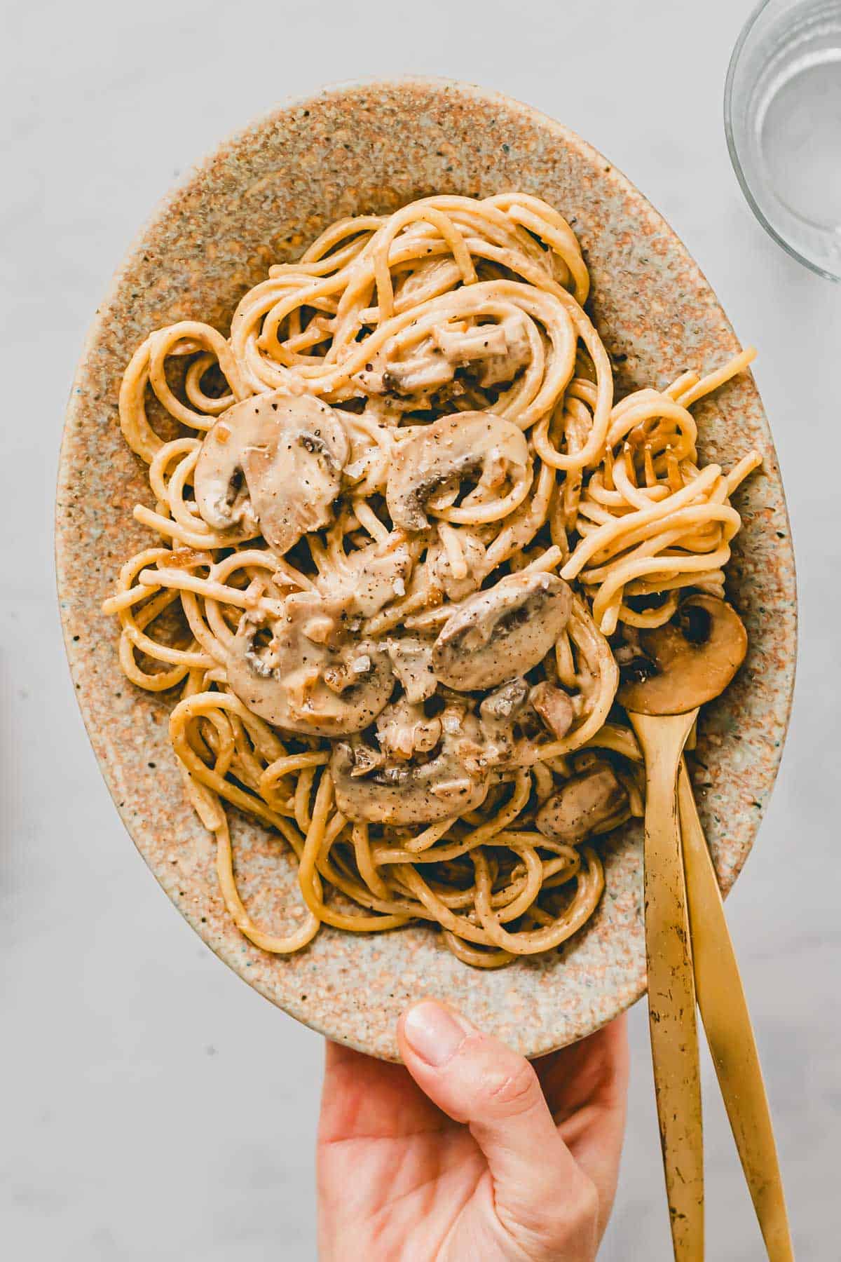 vegane spaghetti carbonara mit rauchigen pilzen auf einem teller serviert