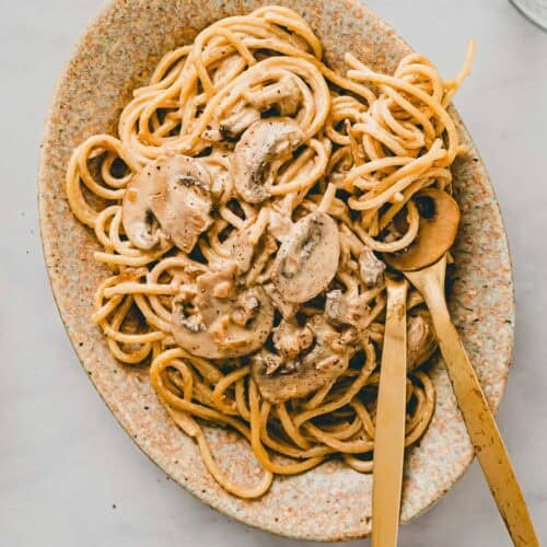 vegane spaghetti carbonara mit rauchigen pilzen auf einem teller serviert