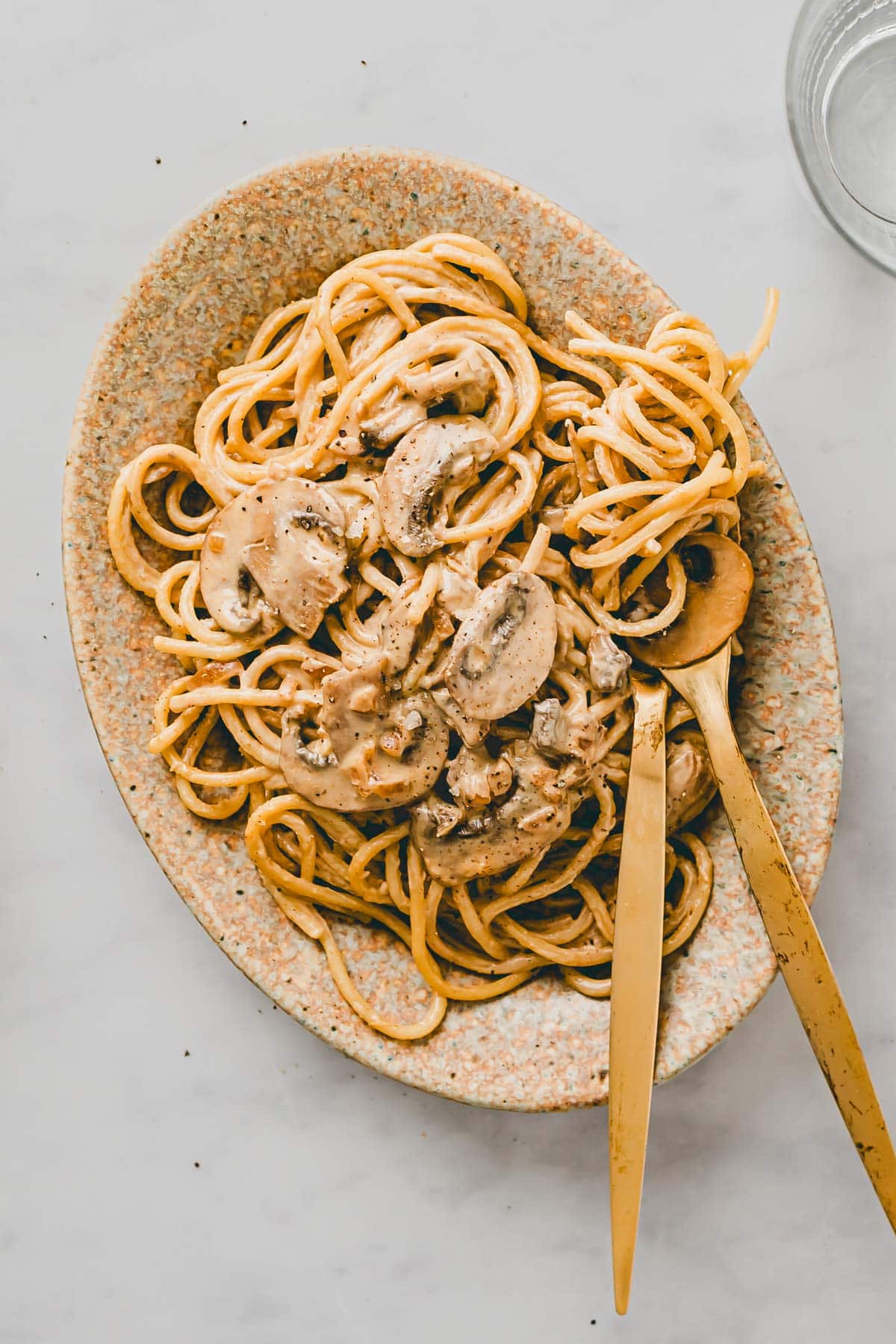 vegane spaghetti carbonara mit rauchigen pilzen auf einem teller serviert