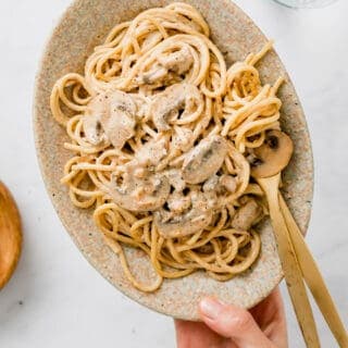 vegan pasta carbonara served on a plate with golden cutlery