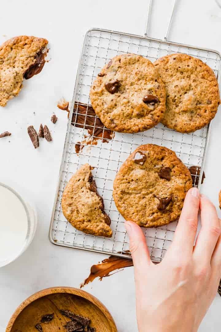 a hand grabbing an eggless peanut butter cookie