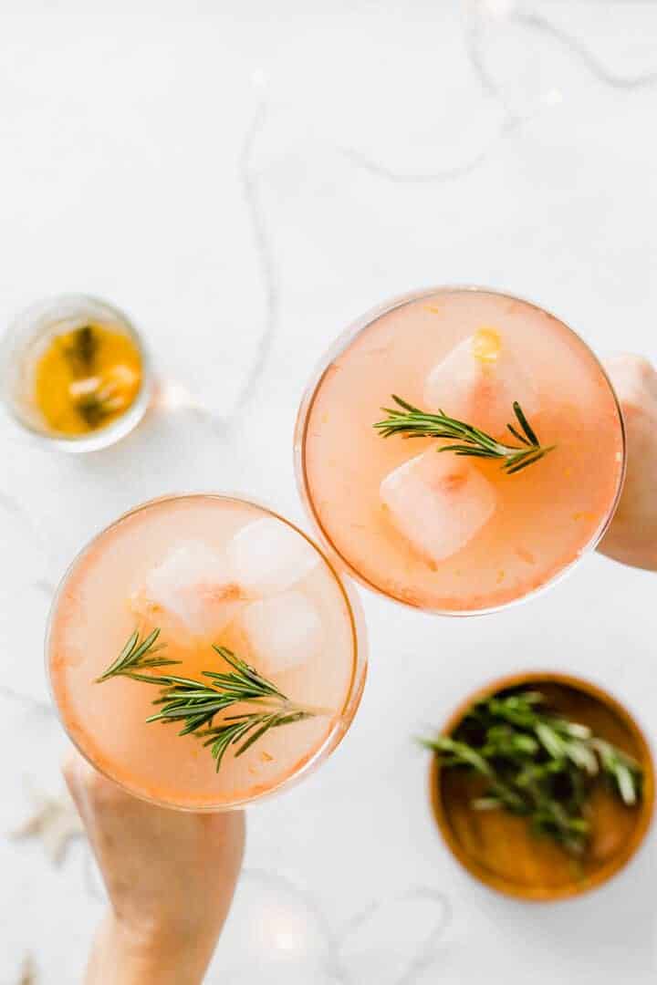 zwei sektschalten mit akoholfreiem grapefruit cocktail mit rosmarin sirup stossen zusammen an