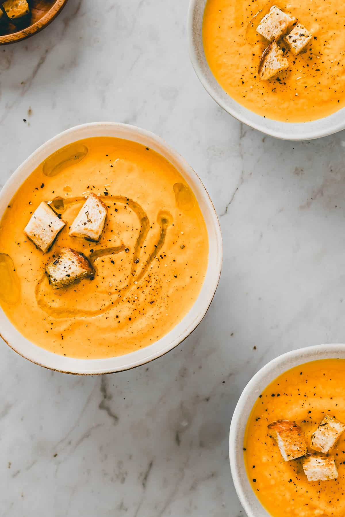 italienische karottensuppe mit orangen in schüssel verteilt