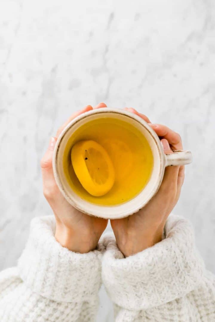 two hand holding a cup of ginger turmeric tea