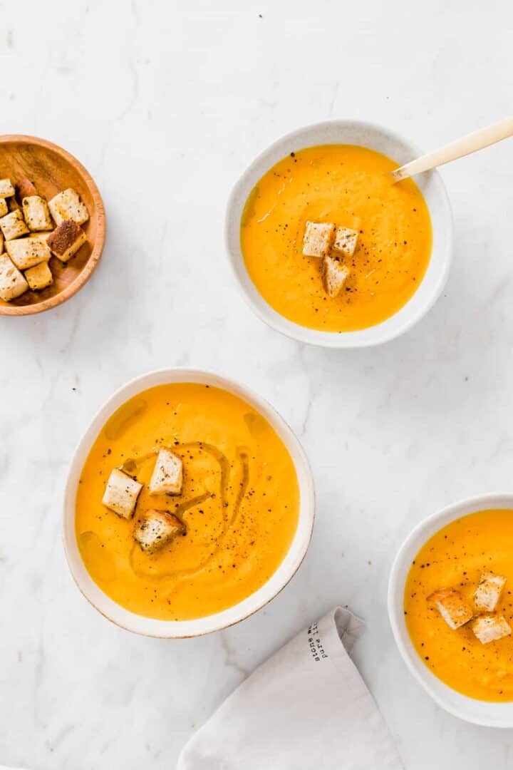 einfache karottensuppe mit croutons in blauen schalen serviert