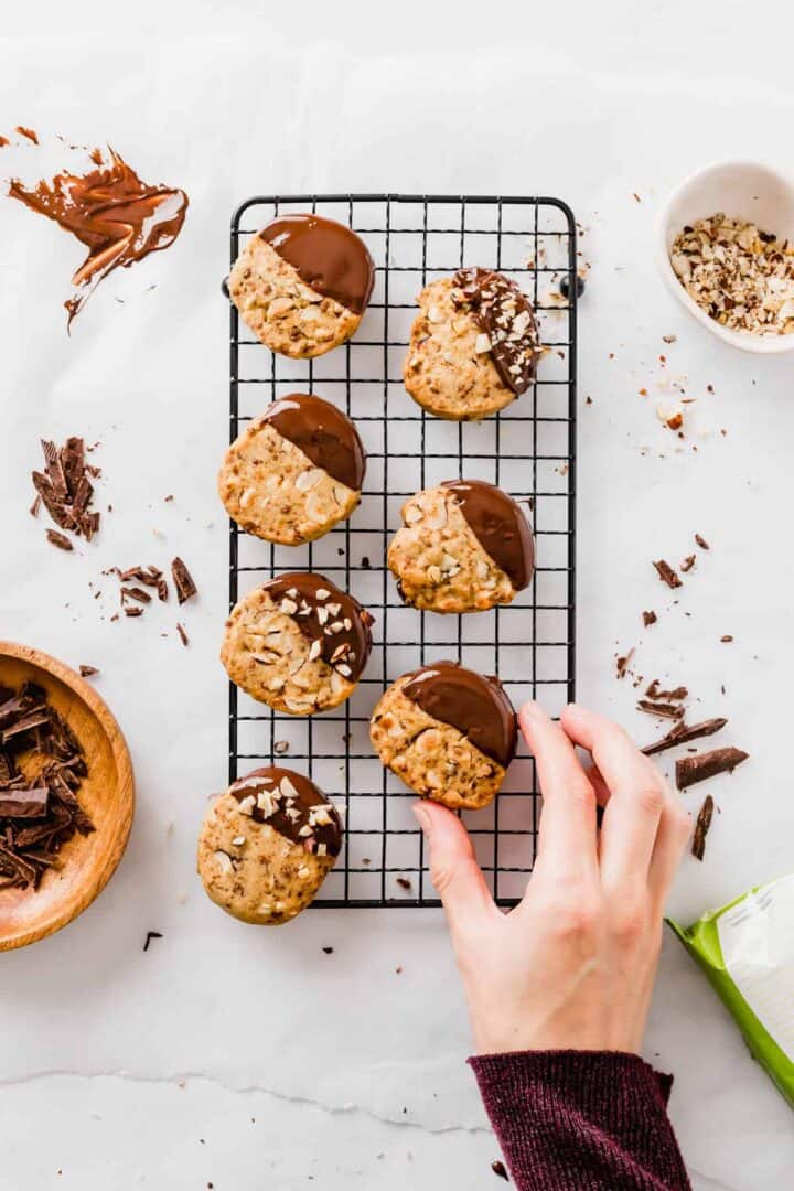 vegan hazelnut cookies with chocolate on a black cooling wrack