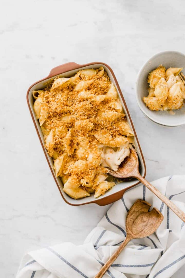 a wooden spoon scooping baked vegan mac and cheese