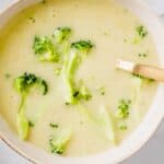 vegan broccoli potato soup served in a bowl with a golden spoon