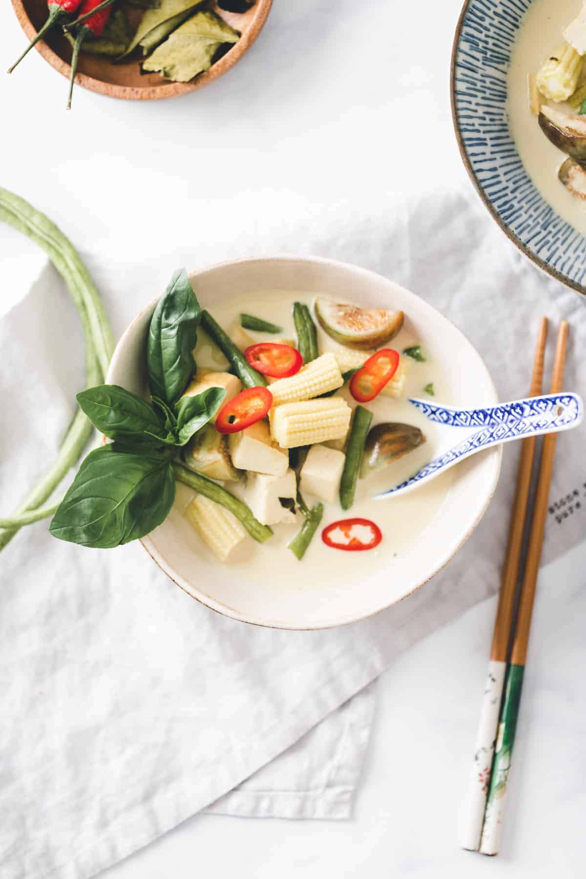 grünes thai curry mit gemüse und tofu in einer schale