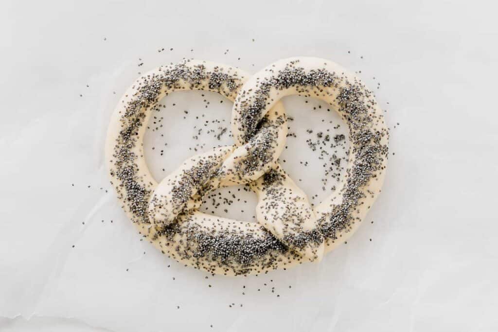 raw pretzel dough sprinkled with poppy seeds