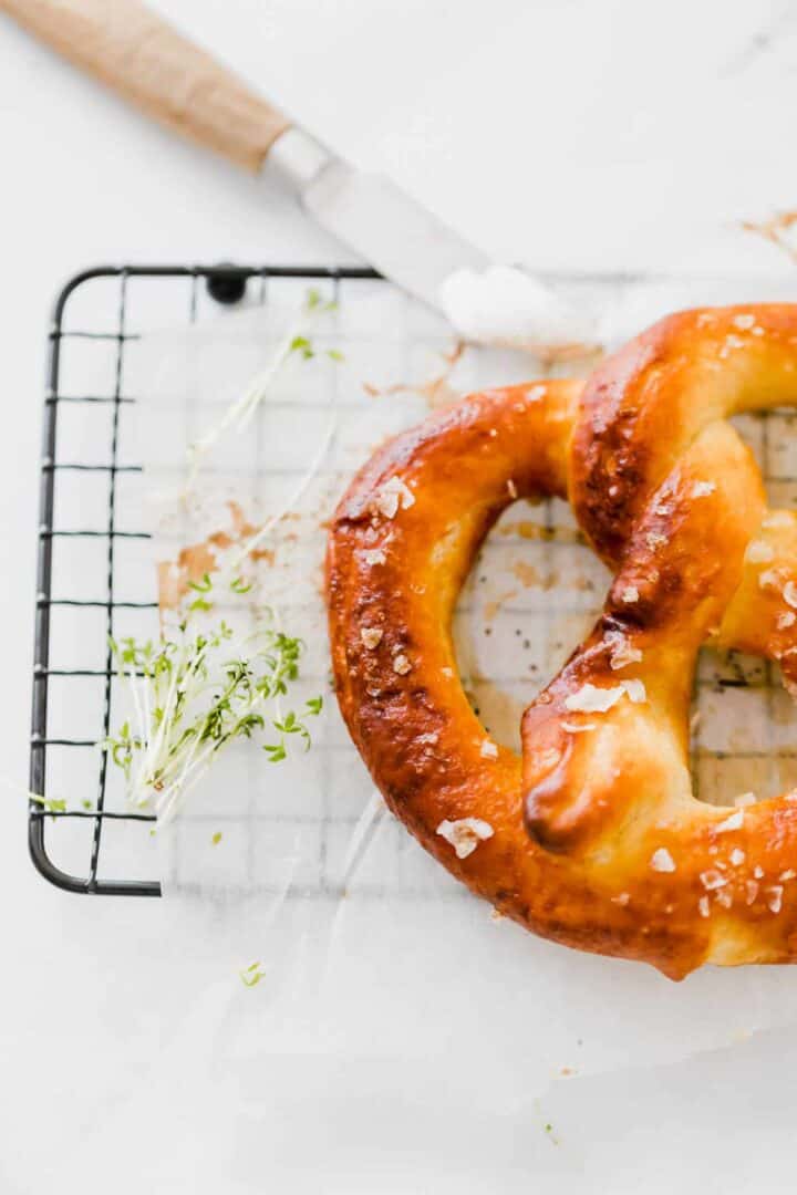 pretzel next to a knife with vegan cream cheese