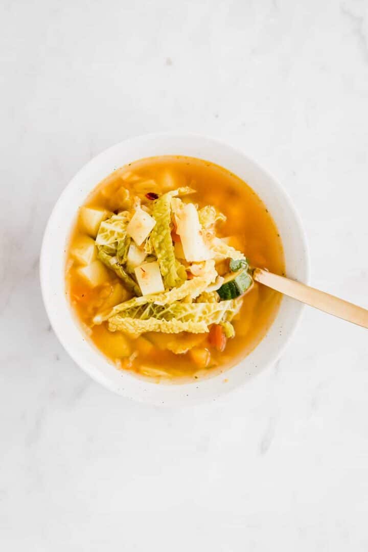 vegetable soup with cabbage and potatoes served in a bowl