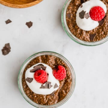 schoko chia pudding mit veganer schlagsahne, himbeeren, und schoko flakes