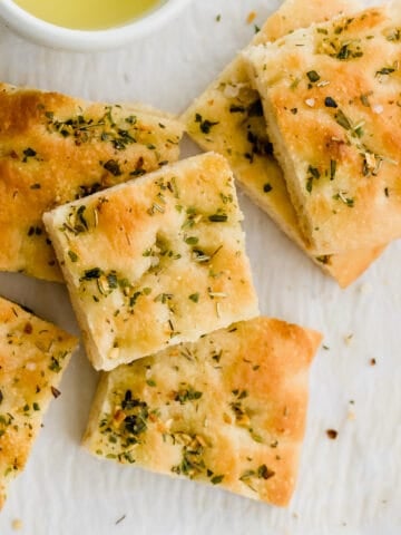 focaccia slices stapled next to a bowl with olive oil