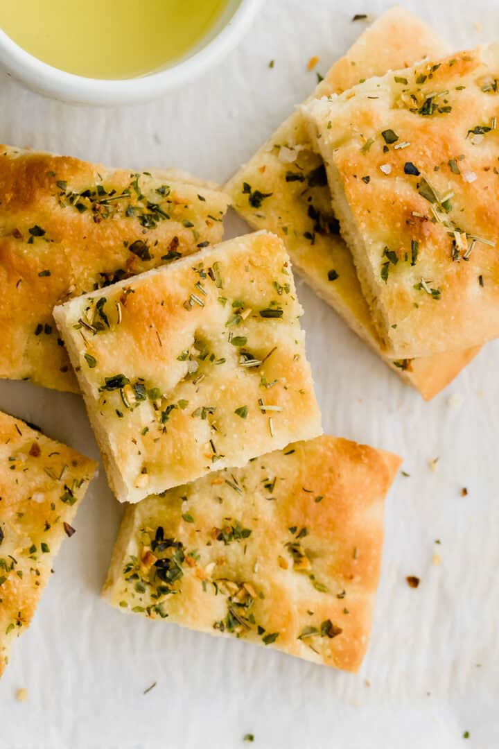 focaccia slices stapled next to a bowl with olive oil