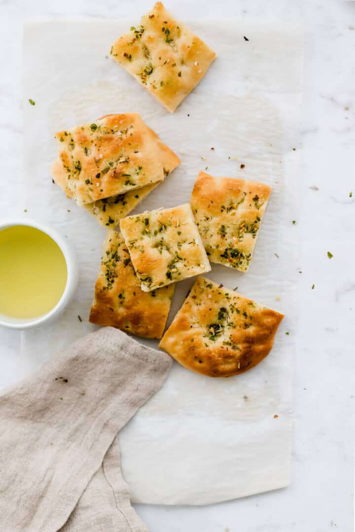 gschnittenes focaccia brot neben einer kleine schale olivenöl