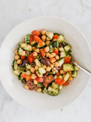 greek chickpea salad in a bowl with a fork