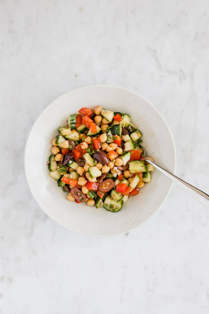 greek chickpea salad in a bowl with a fork