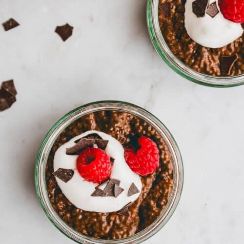schoko chia pudding in zwei gläsern mit himbeeren dekoriert