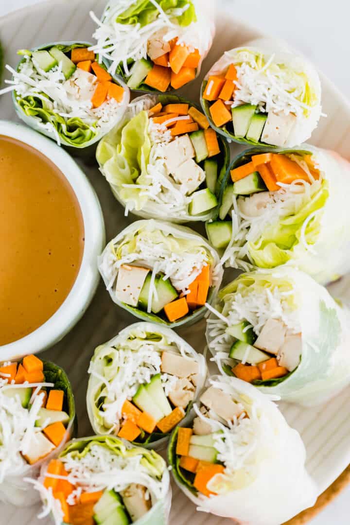 vegan rice paper rolls on a plate with peanut sauce