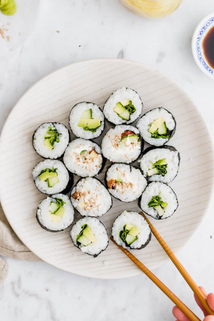 two chopsticks taking a sushi roll