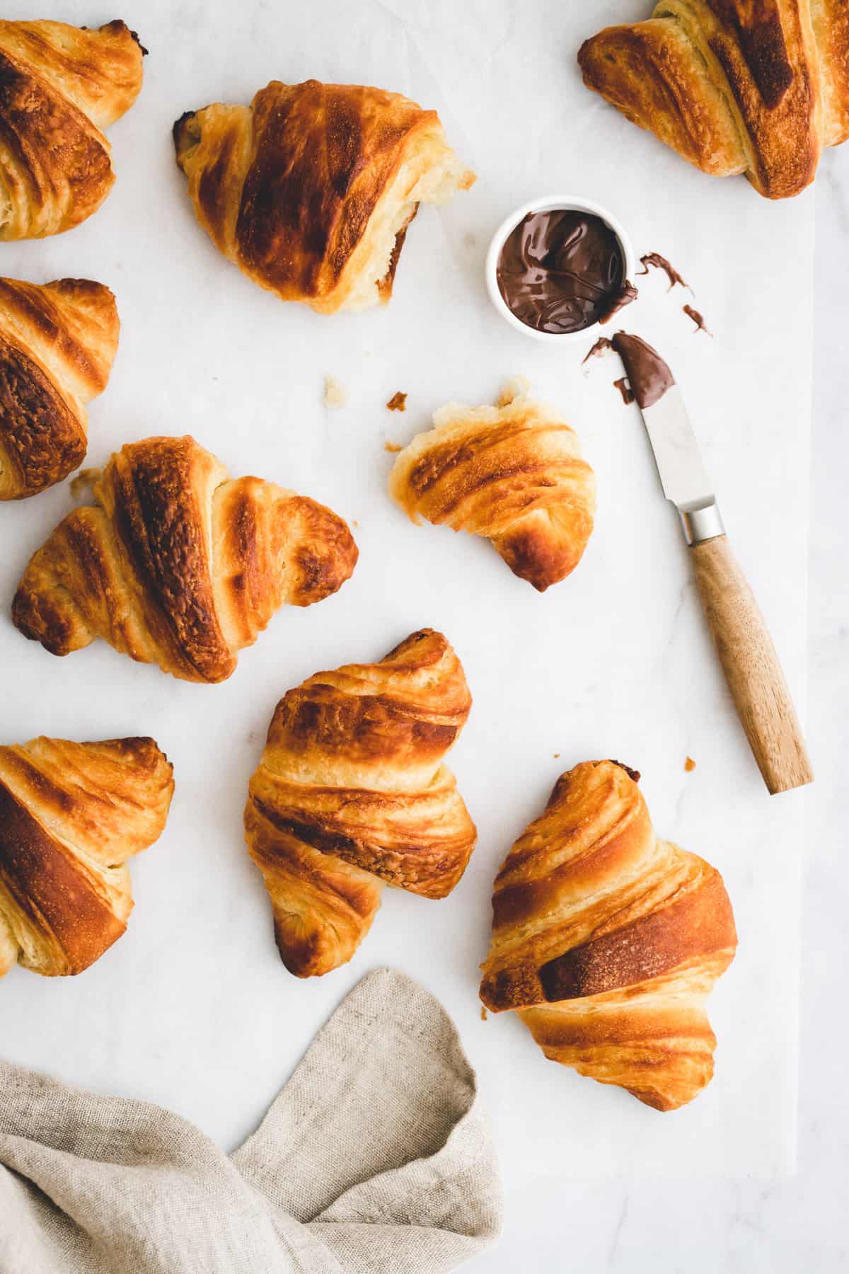 vegane croissants neben einem messer mit schokoladenaufstrich