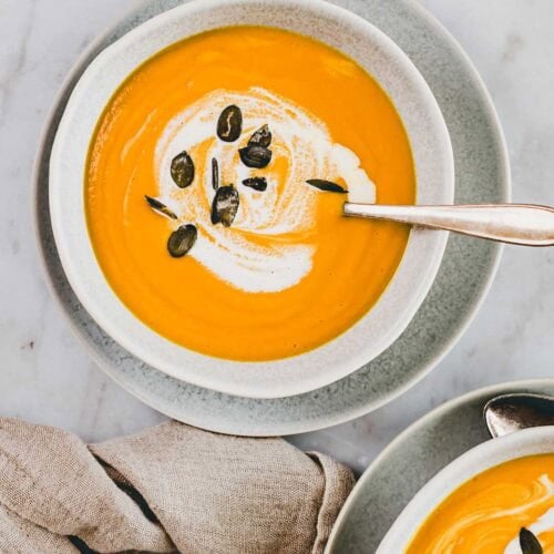 Pumpkin Ginger Soup with coconut milk served in two small bowls