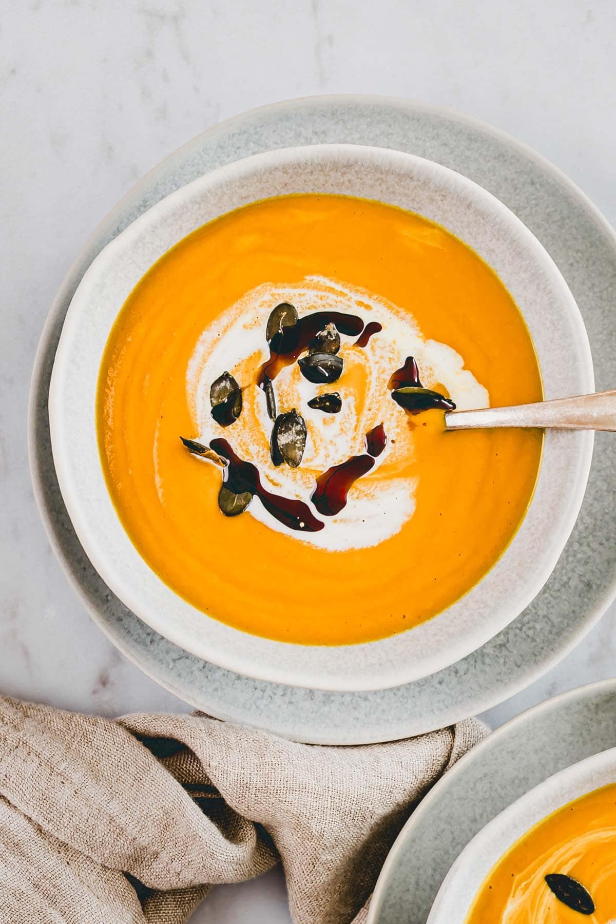 a bowl of Pumpkin Ginger Soup with coconut milk photographed from overhead