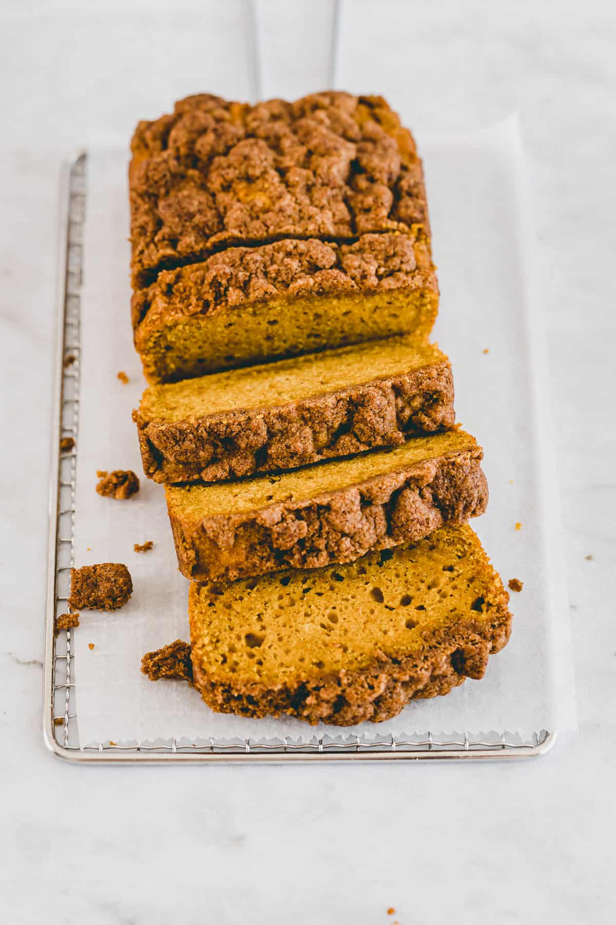 veganer kürbiskuchen mit streusel auf einem gitter