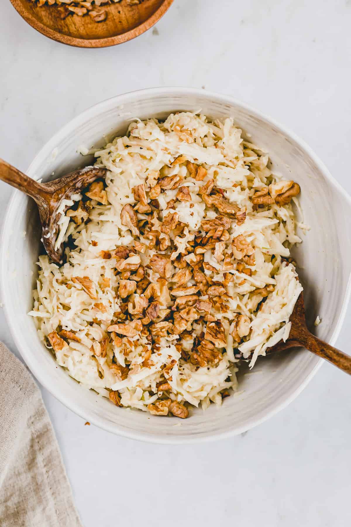 celeriac salad in a large bowl topped with walnuts