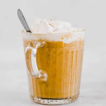 pumpkin spice latte with dairy-free whipped cream in a glass mug