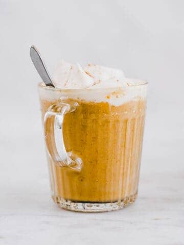 kürbis latte mit schlagsahne und zimt in einer glastasse