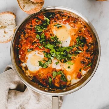 shakshuka in einer pfanne mit frischem kräutern dekoriert