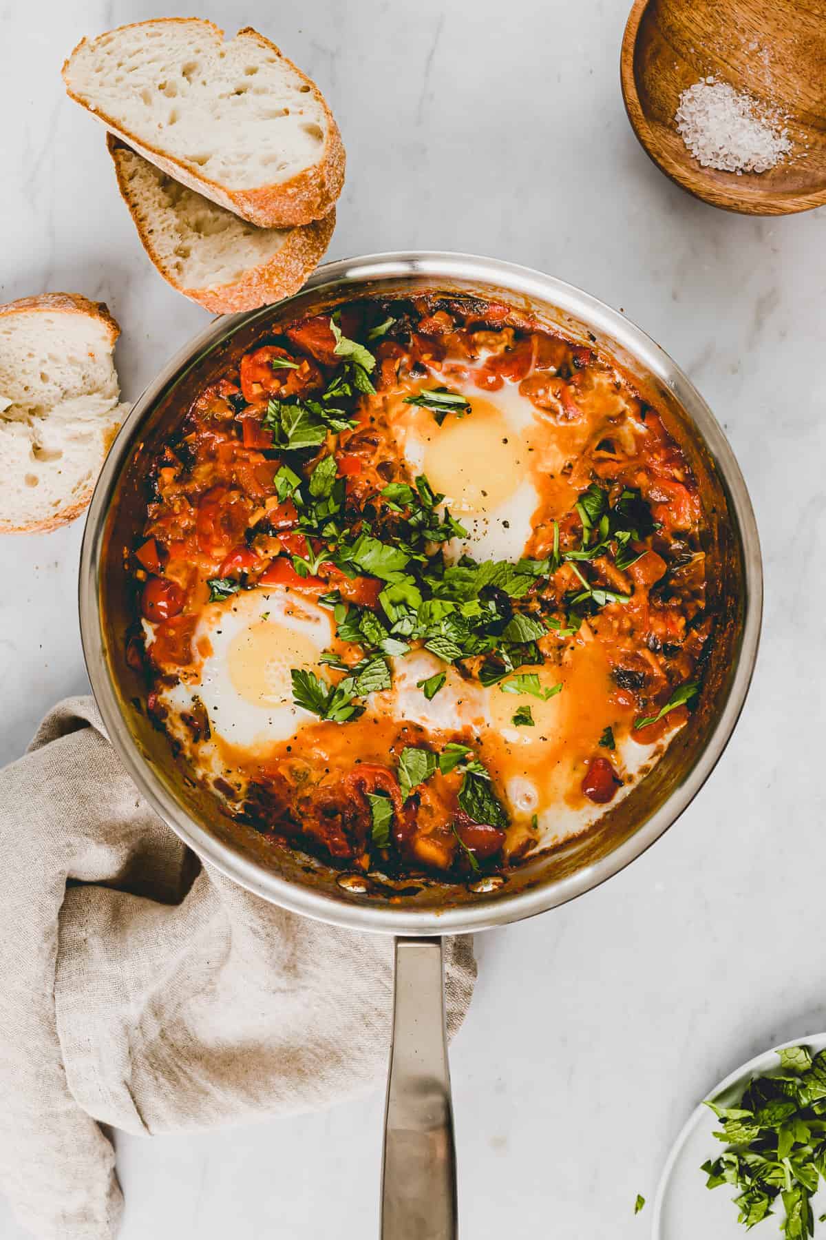 shakshuka in a skillet topped with fresh herbs