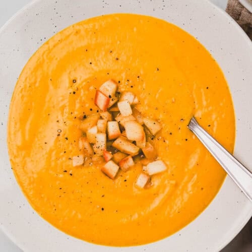 Süsskartoffelsuppe mit Kokosmilch und Apfel Topping in einem teller