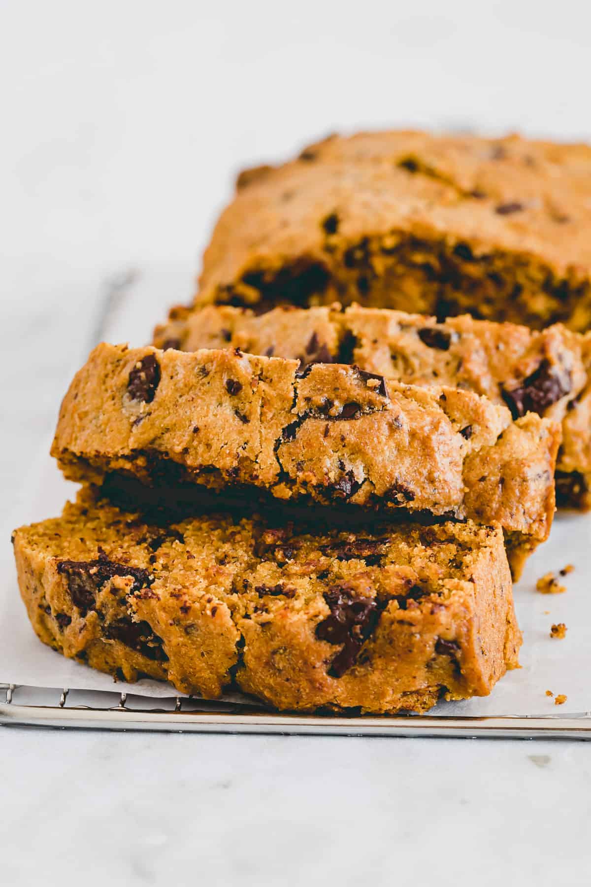 slices of vegan pumpkin bread with chocolate chips on a cooling rack